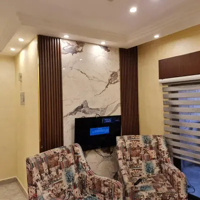 two chairs in a room with a marble wall at Apartment no 30 in Amman