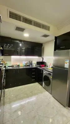 a kitchen with black cabinets and stainless steel appliances at Apartment no 30 in Amman