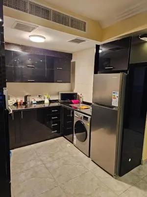 a kitchen with stainless steel appliances and black cabinets at Apartment no 30 in Amman