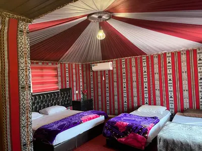 two beds in a room with a tent at Rum Bacific camp in Wadi Rum