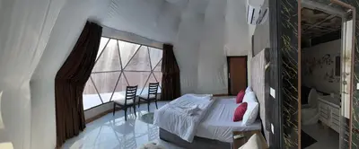 a bedroom with a bed and a large window at Rum Bacific camp in Wadi Rum