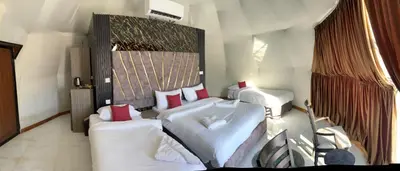 a bedroom with two beds with white sheets and red pillows at Rum Bacific camp in Wadi Rum