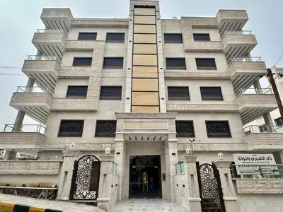 a tall white building with a doorway in front of it at شقق فندقية فاخرة عمّان in Amman
