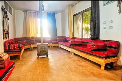a living room with red couches and a fireplace at Al-Karak Countryside and hotel in Ad Dimnah