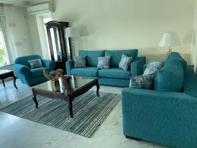 a living room with two blue couches and a coffee table at Khalda Renovated 3 Bedroom Apartment in Amman