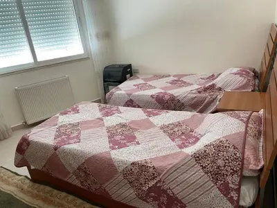 a bedroom with two beds and a quilt at Khalda Renovated 3 Bedroom Apartment in Amman