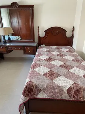 a bedroom with a quilt on a bed and a dresser at Khalda Renovated 3 Bedroom Apartment in Amman