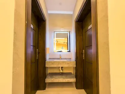 a bathroom with a sink and a mirror and two doors at Petra Karam Hotel in Wadi Musa
