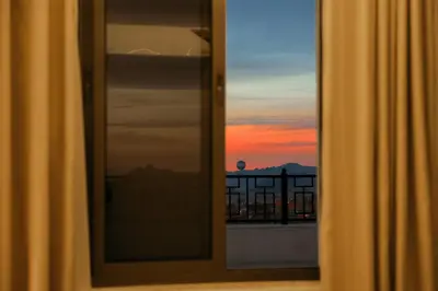 a window with a view of a sunset at Petra Karam Hotel in Wadi Musa