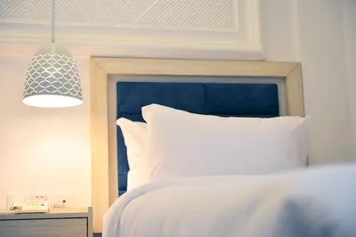 a bedroom with a bed with a blue head board at Petra Karam Hotel in Wadi Musa