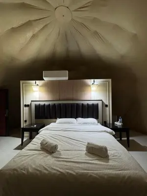 a bedroom with a large bed with two towels on it at Glow of Wadi Rum Camp in Wadi Rum