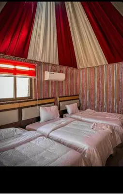two beds in a room with a tent at Glow of Wadi Rum Camp in Wadi Rum