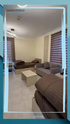 a living room with couches and a couch and a table at gardens st 2 beds apartment 411 in Amman