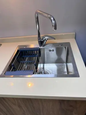 a kitchen sink with a dish drying rack in it at new furnished studio gardens st 329 in Amman