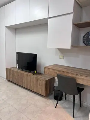a living room with a television and a table and a chair at new furnished studio gardens st 329 in Amman