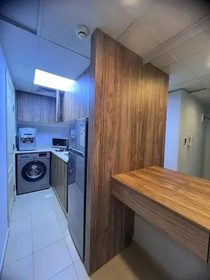 a kitchen with a wooden counter and a washer and dryer at new furnished studio gardens st 329 in Amman