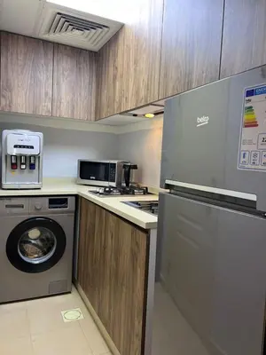 a kitchen with a washing machine and a microwave at new furnished studio gardens st 329 in Amman