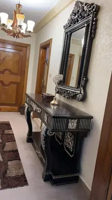 a black desk with a mirror on a wall at شقه مفروشه مع حديقه اربد بجانب فندق فلامنجو ومدارس دار العلوم in Irbid