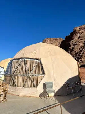 a dome tent with two chairs and a chair in front at Desert Boulevard Camp in Wadi Rum