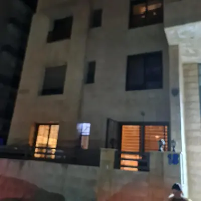 a building with windows and a man standing in front of it at 2bd apartment 32 in Amman