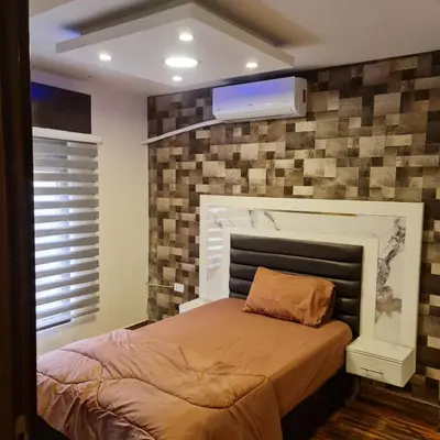 a bedroom with a bed with a tv on the wall at 2bd apartment 32 in Amman