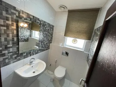 a bathroom with a sink and a toilet and a mirror at Modern 2-Bedroom Apartment in a Vibrant Neighborhood in Amman