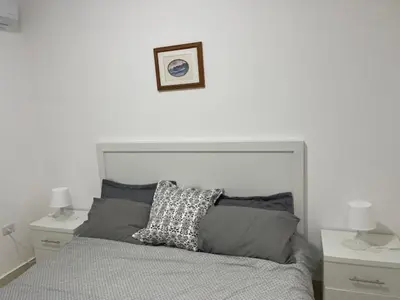 a bedroom with a large bed with two night stands at Deadsea Elite second floor shared swimming pool in Sowayma