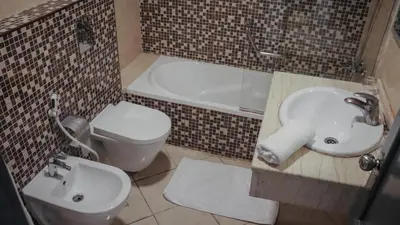 a bathroom with a toilet and a sink and a tub at Sandy palace Hotel in Amman