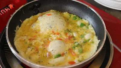 a pan filled with eggs and vegetables on a table at Sandy palace Hotel in Amman