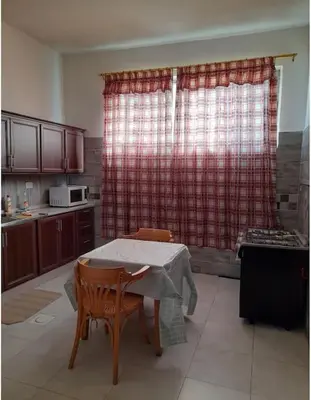 a kitchen with a table and two chairs and a table and a window at 3bedrooms apt near paris square in Amman