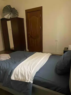 a bedroom with a bed and a wooden door at 3bedrooms apt near paris square in Amman