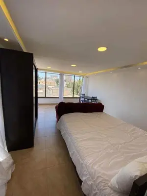 a bedroom with a large bed and a large window at The view III in Amman