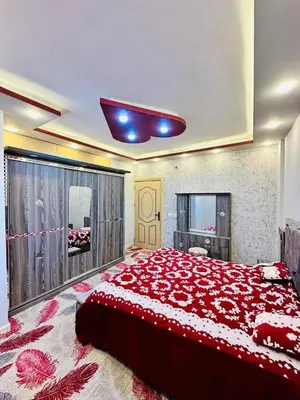 a large bedroom with a large bed with red sheets at Margaret from Petra cave house in Wadi Musa