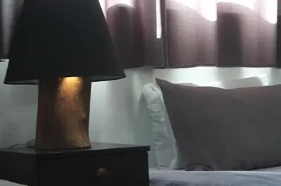 a lamp on a night stand next to a bed at Value Place in Wadi Musa
