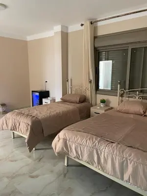 a bedroom with two beds and a window at Airport Villa Amman in Amman