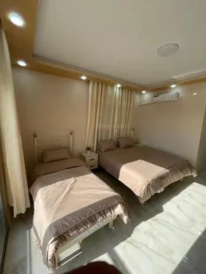 two beds are in a room withermottermottermott at Airport Villa Amman in Amman
