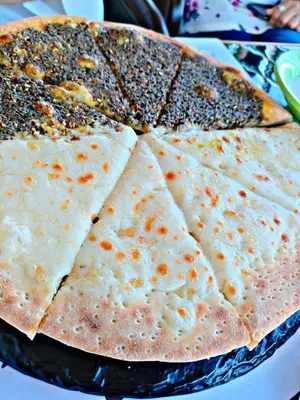 a close up of a pizza with four slices at Dana Star lodge in Dana