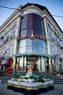 a large building with a fountain in front of it at Sama Paris Plaza Hotel in Amman