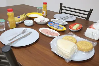 a wooden table with plates of food on it at Salvador Dali Apartments in Amman