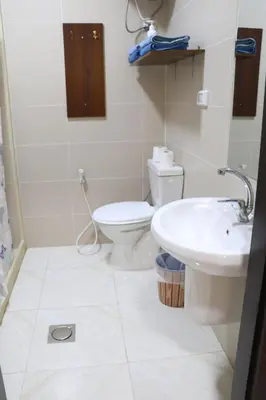 a white bathroom with a toilet and a sink at Salvador Dali Apartments in Amman