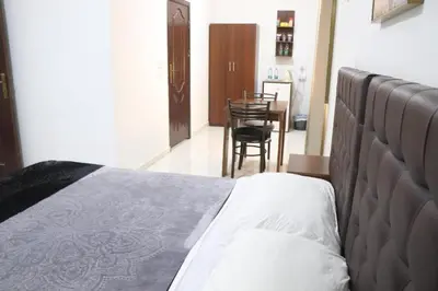 a bedroom with a bed and a table and chairs at Salvador Dali Apartments in Amman