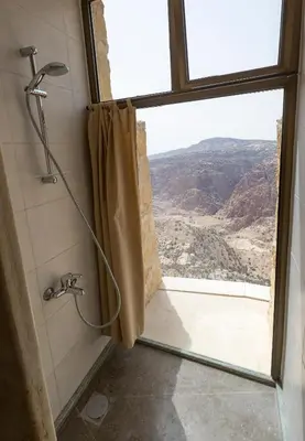 a bathroom with a shower with a view of a canyon at Dana Guesthouse in Dana