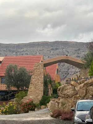 a car parked in front of a house with a stone wall at Dana luxury huts in Dana