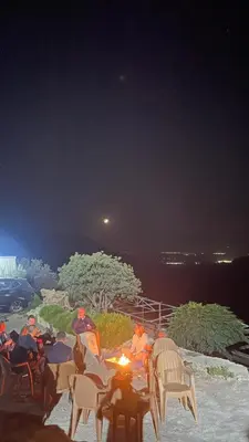a group of people sitting around a table at night at Dana luxury huts in Dana