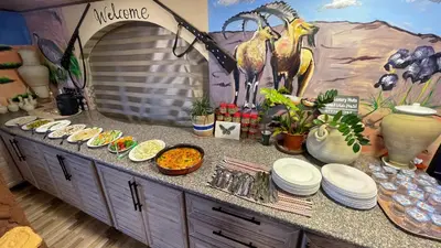 a table with plates of food on a counter with a mural at Dana luxury huts in Dana