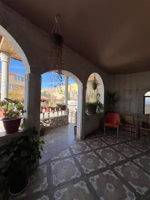 a room with arched windows and a red chair at Bedouin family home in Wadi Musa