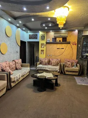 a living room with couches and a table and a chandelier at Bedouin family home in Wadi Musa