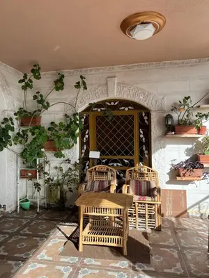 a room with two rattan chairs and a table at Bedouin family home in Wadi Musa