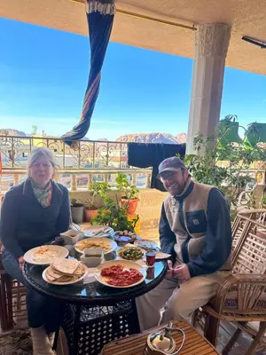a man and woman sitting at a table with food at Bedouin family home in Wadi Musa