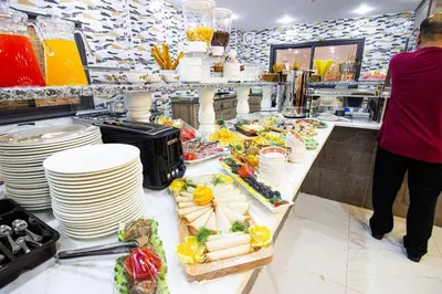 a buffet line with plates and food in a restaurant at Beirut Hotel 2 in Amman